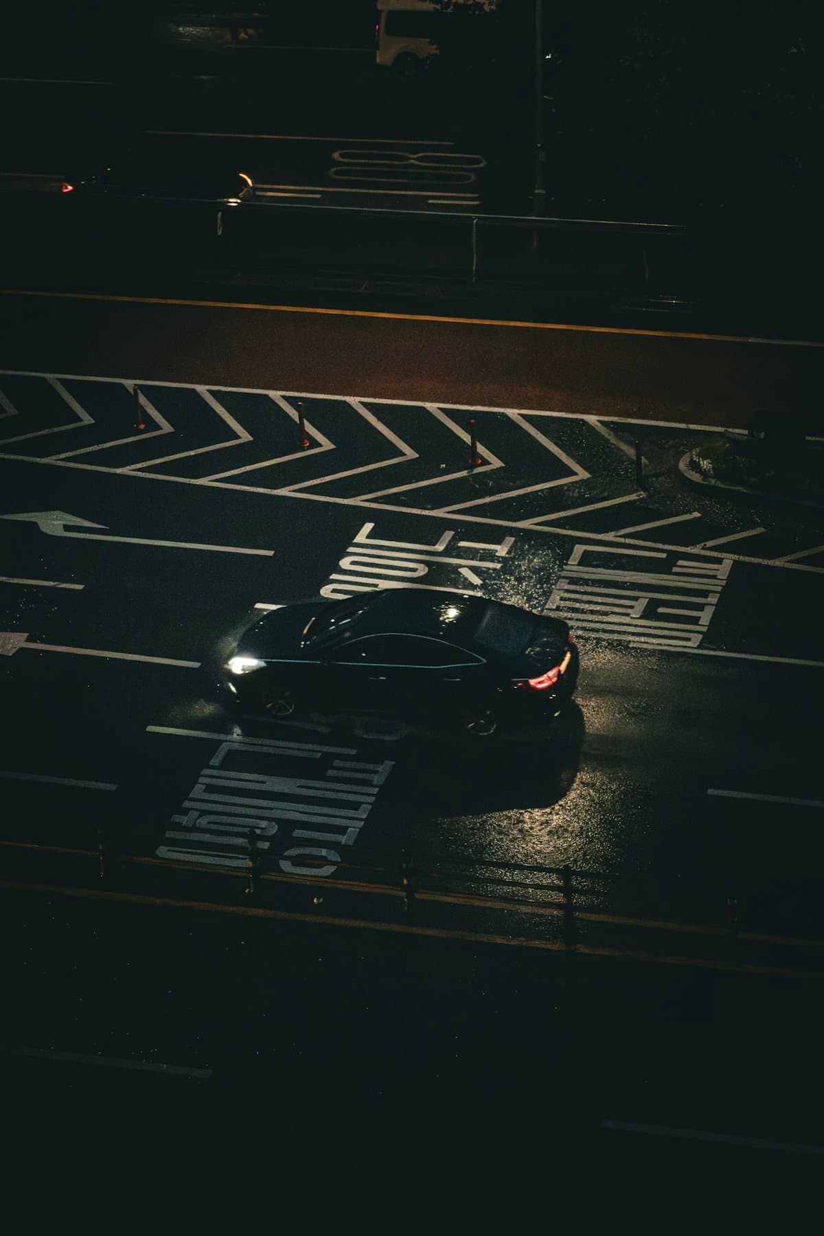 Berlina negra cruzando un paso urbano de noche